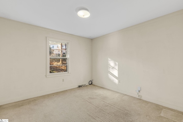 carpeted empty room featuring crown molding