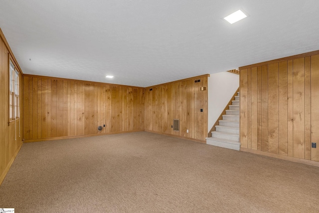 basement with light carpet and wooden walls