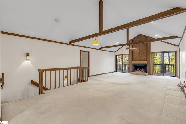 unfurnished living room featuring ceiling fan, a large fireplace, carpet floors, and beamed ceiling