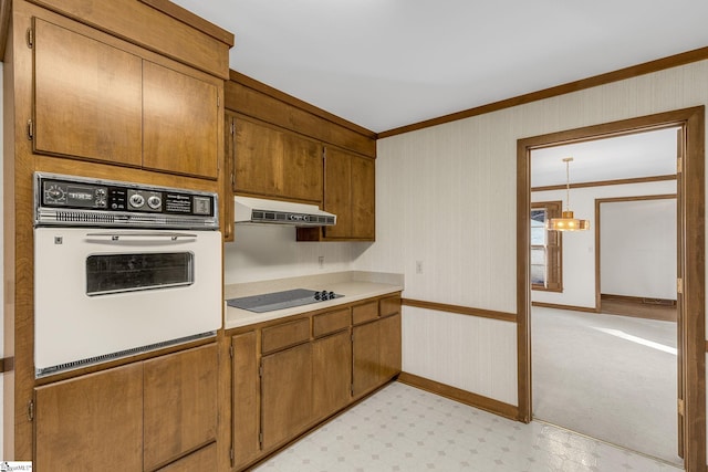 kitchen with white oven, crown molding, black electric cooktop, and hanging light fixtures