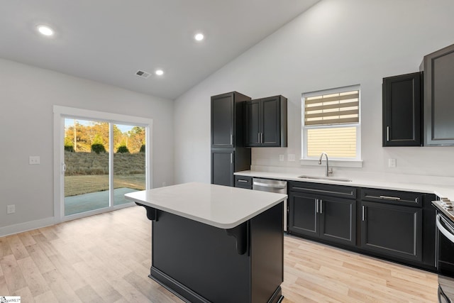 kitchen featuring light hardwood / wood-style floors, sink, a breakfast bar area, and a kitchen island