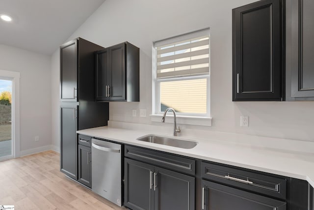 kitchen featuring light wood-type flooring, lofted ceiling, stainless steel dishwasher, and sink