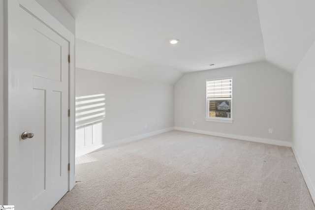 bonus room with light carpet and lofted ceiling