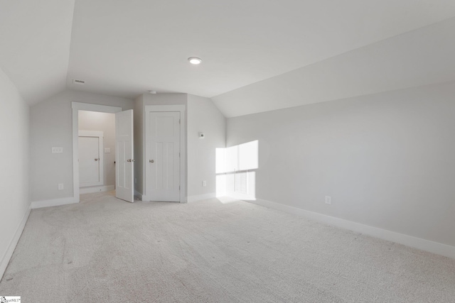 additional living space with light carpet and lofted ceiling