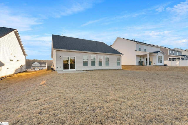 back of property with a yard and a patio