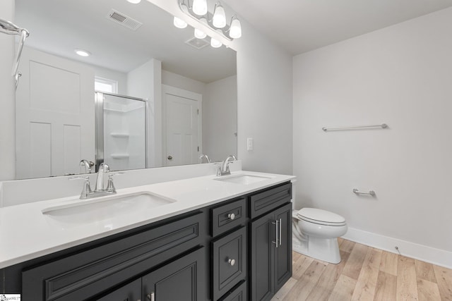 bathroom featuring toilet, wood-type flooring, vanity, and an enclosed shower