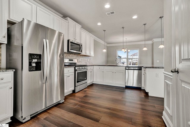 kitchen featuring white cabinets, pendant lighting, appliances with stainless steel finishes, and dark stone countertops