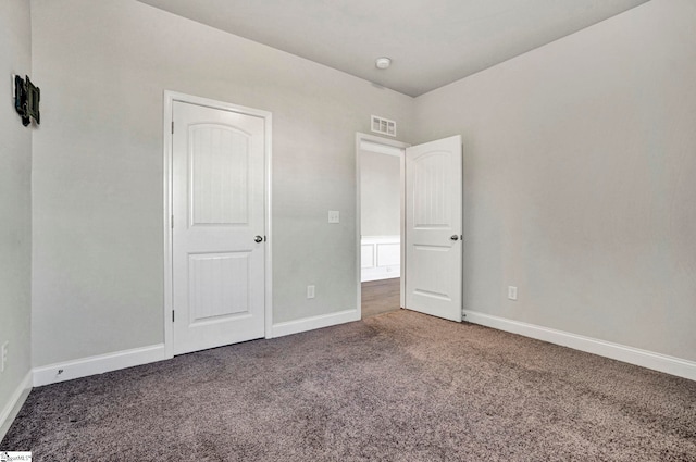 unfurnished bedroom featuring dark carpet