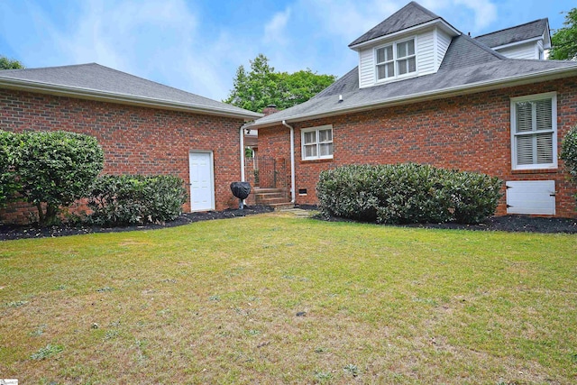 rear view of property with a yard