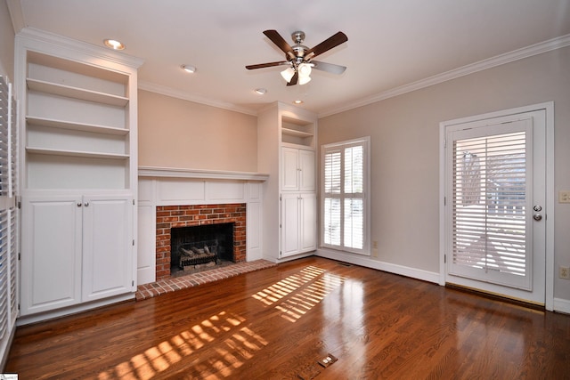 unfurnished living room featuring dark wood-type flooring, ceiling fan, a fireplace, and crown molding