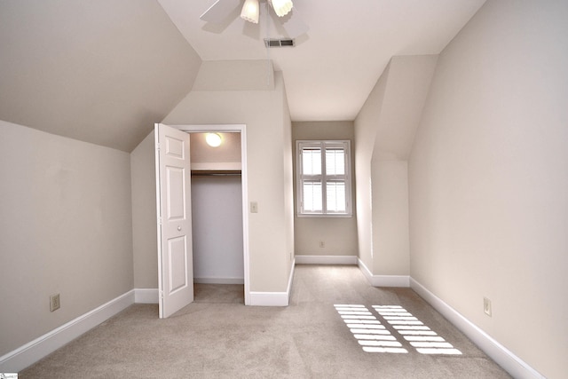 additional living space with ceiling fan, lofted ceiling, and light colored carpet