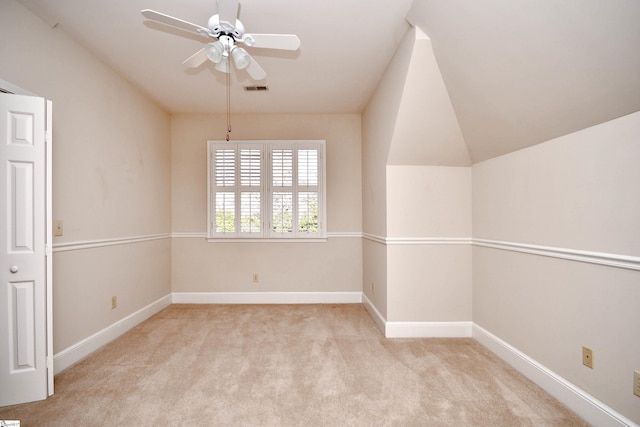 carpeted empty room with ceiling fan and lofted ceiling