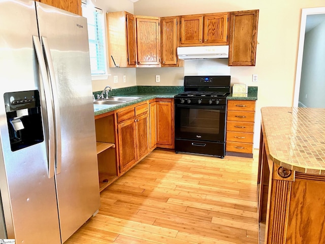 kitchen with sink, stainless steel fridge, black range with gas cooktop, and light hardwood / wood-style flooring