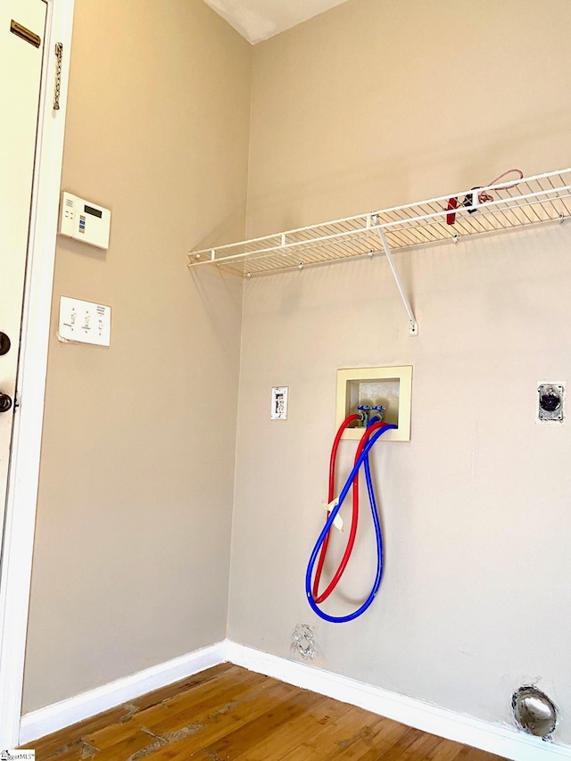 clothes washing area featuring dark hardwood / wood-style flooring, hookup for a gas dryer, hookup for a washing machine, and hookup for an electric dryer