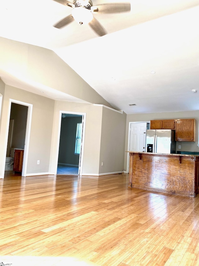 unfurnished living room featuring light hardwood / wood-style floors, lofted ceiling, and ceiling fan