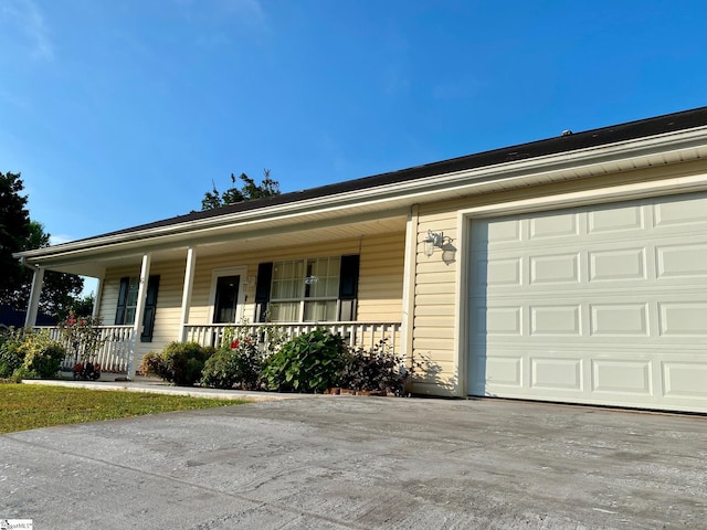 single story home with covered porch and a garage