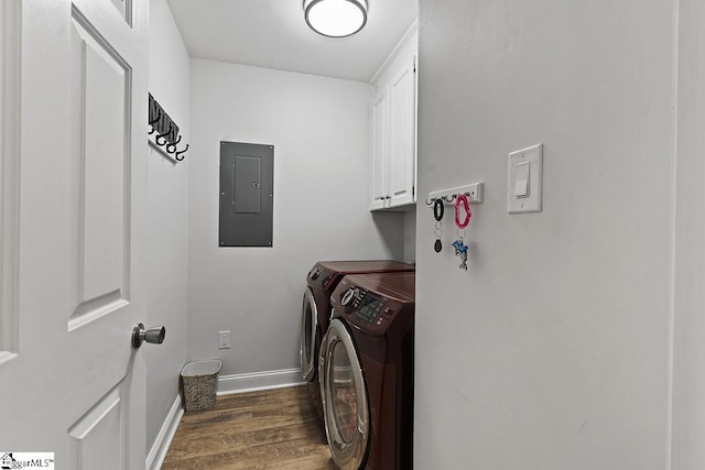 laundry room featuring dark wood-type flooring, cabinets, electric panel, and washer and clothes dryer