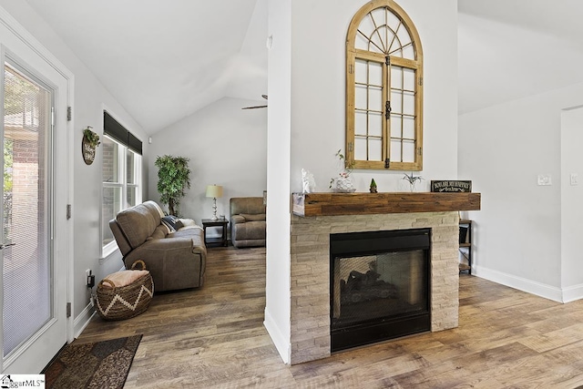 living room featuring ceiling fan, lofted ceiling, a fireplace, and hardwood / wood-style flooring