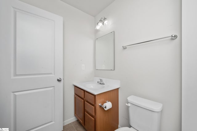 bathroom with toilet, vanity, and tile patterned flooring