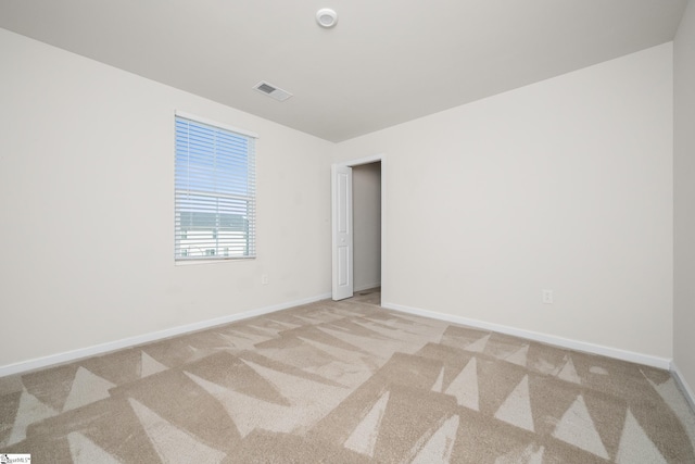 spare room featuring light carpet