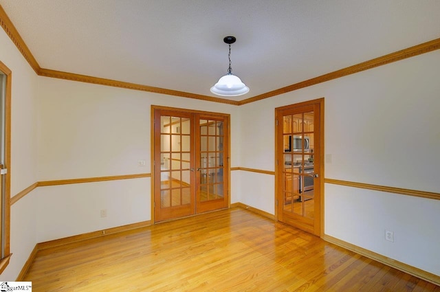 spare room with hardwood / wood-style flooring, ornamental molding, and french doors