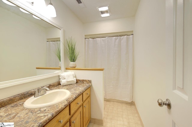 bathroom with vanity, a textured ceiling, and curtained shower