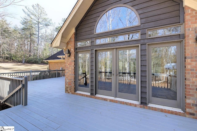 view of exterior entry featuring french doors and a deck