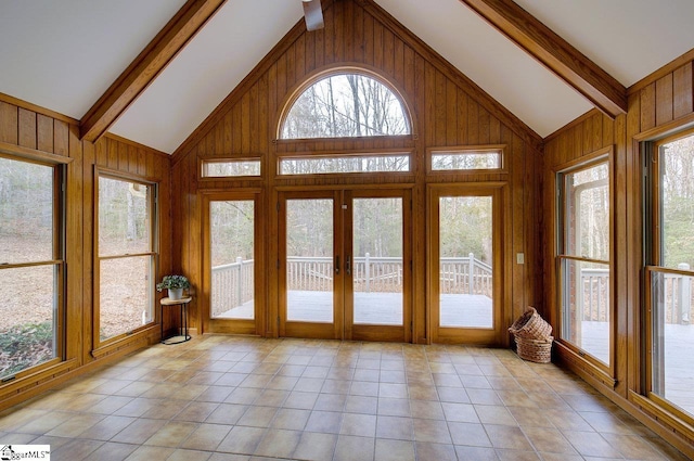 unfurnished sunroom featuring vaulted ceiling with beams and french doors