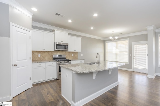 kitchen featuring white cabinetry, appliances with stainless steel finishes, a center island with sink, and sink