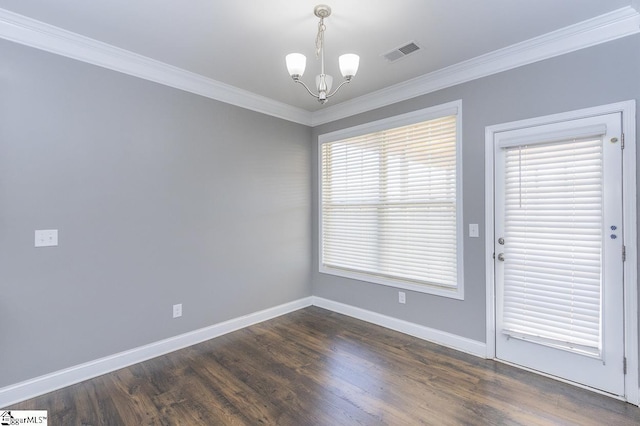 spare room featuring dark hardwood / wood-style flooring, a chandelier, and ornamental molding