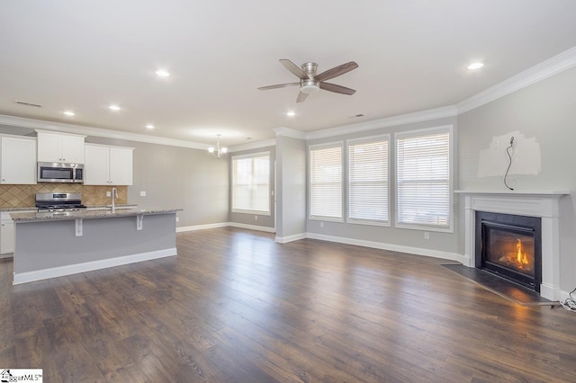 unfurnished living room with dark hardwood / wood-style flooring, crown molding, and sink