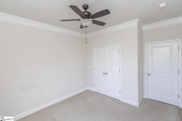 unfurnished bedroom with ceiling fan, light colored carpet, a closet, and ornamental molding