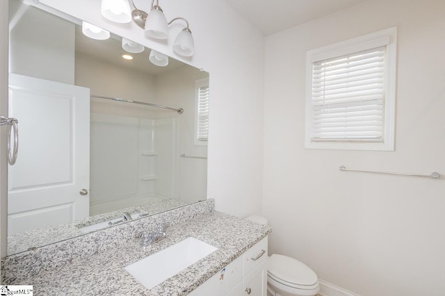 bathroom with toilet, a shower, and vanity