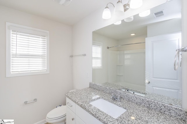 bathroom with toilet, vanity, and a shower