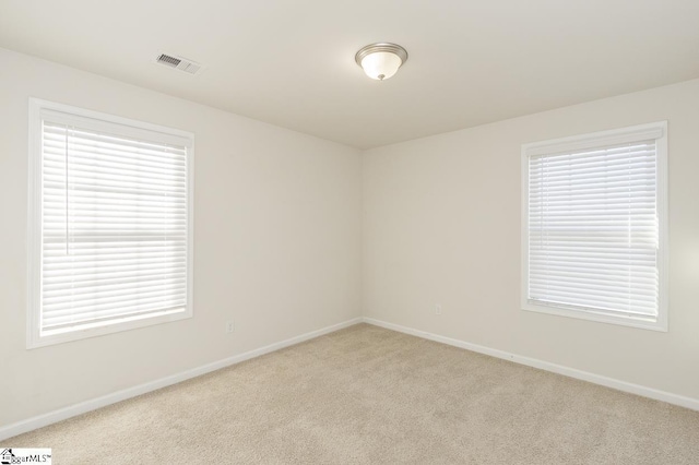 unfurnished room with a healthy amount of sunlight and light colored carpet