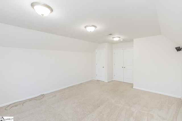 interior space with light colored carpet and vaulted ceiling