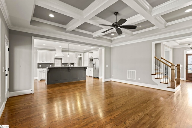 unfurnished living room featuring beamed ceiling, crown molding, and coffered ceiling