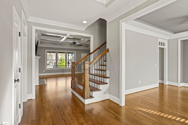 stairway featuring ceiling fan, hardwood / wood-style floors, beamed ceiling, coffered ceiling, and ornamental molding