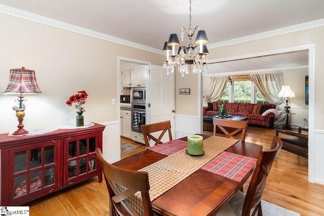 dining room featuring light wood-type flooring, an inviting chandelier, and ornamental molding