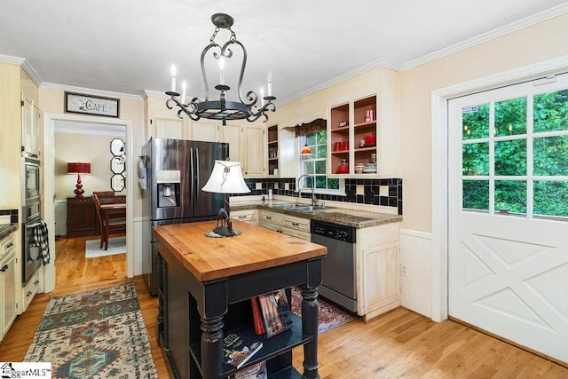 kitchen featuring wood counters, decorative light fixtures, stainless steel appliances, an inviting chandelier, and sink