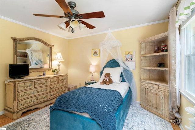 bedroom featuring ceiling fan, crown molding, and light wood-type flooring