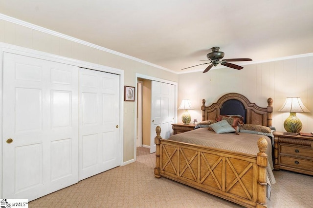 carpeted bedroom with ceiling fan, ornamental molding, and multiple closets