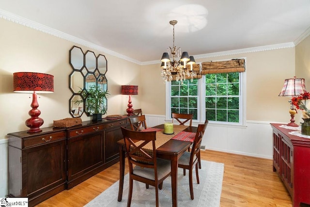 dining room with an inviting chandelier, ornamental molding, and light hardwood / wood-style floors