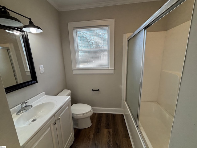 full bathroom featuring shower / bath combination with glass door, vanity, toilet, ornamental molding, and hardwood / wood-style flooring