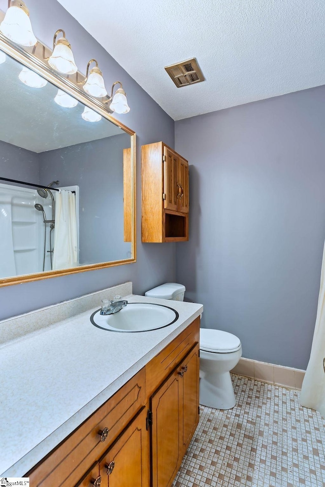 bathroom featuring toilet, vanity, tile patterned floors, a shower with curtain, and a textured ceiling