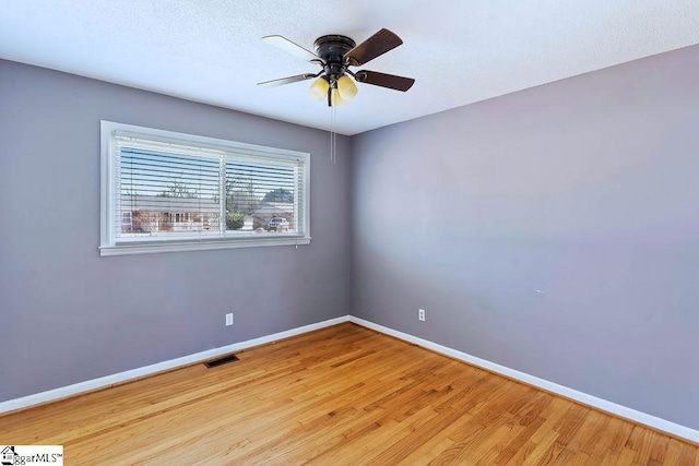 empty room with ceiling fan and light hardwood / wood-style floors