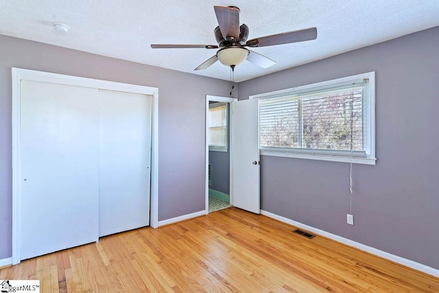 unfurnished bedroom featuring ceiling fan, a closet, and light hardwood / wood-style floors