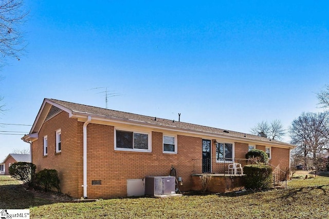 back of property with a lawn and central AC