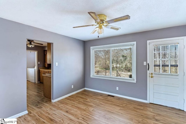 interior space featuring a textured ceiling, ceiling fan, and light hardwood / wood-style flooring