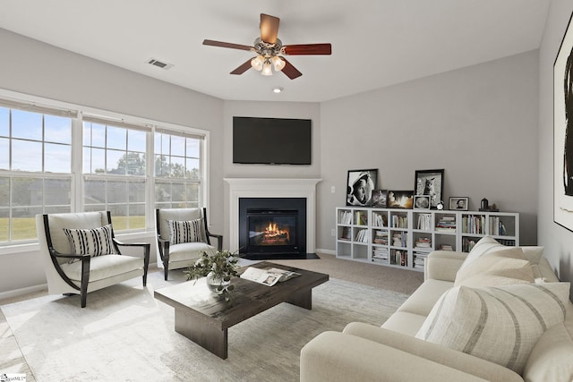 carpeted living room with ceiling fan